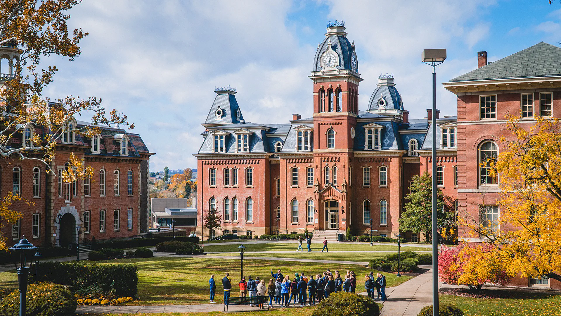 A tour group standing in front of Woodburn Hall