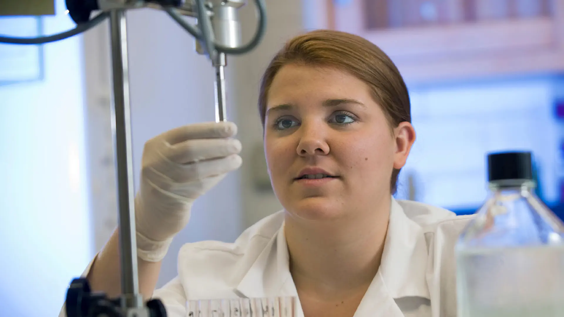 Student adjusts a piece of lab equipment